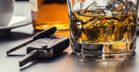 car keys and glass of alcohol on table