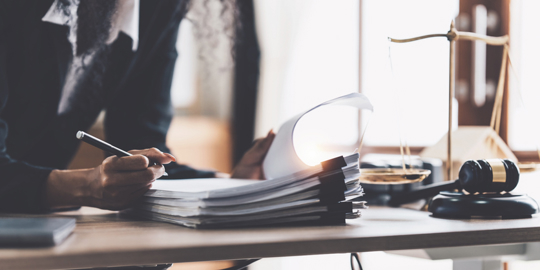 Lawyer reviewing stack of documents